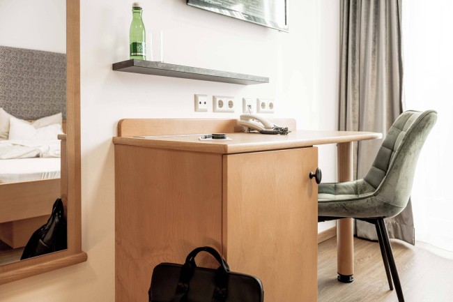 Blick auf Schreibtisch und Balkontüre im SINGLE Room