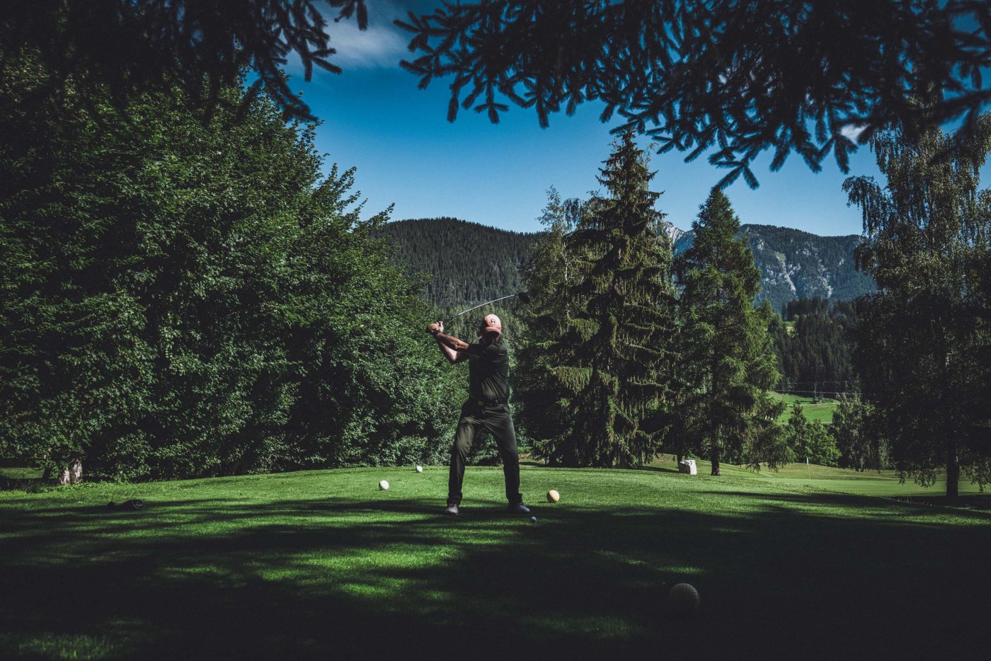 Golfer schwingt auf traumhaften Fleck zwischen Wald und Hügel